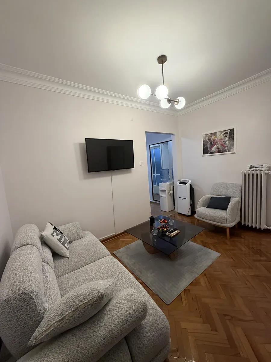 Gri kanepe ve cam sehpasıyla bekleme alanı