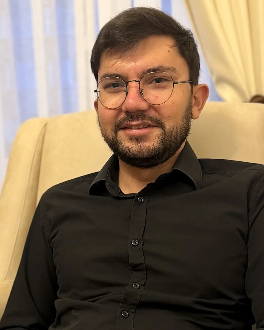 Selman Yetkin, ofisinde sakin bir ifadeyle kameraya bakıyor